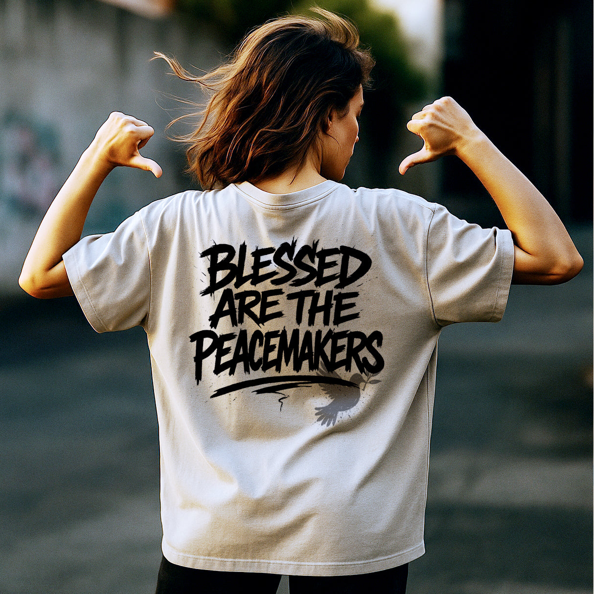 Person wearing a t-shirt with 'Blessed are the Peacemakers' text on the back.