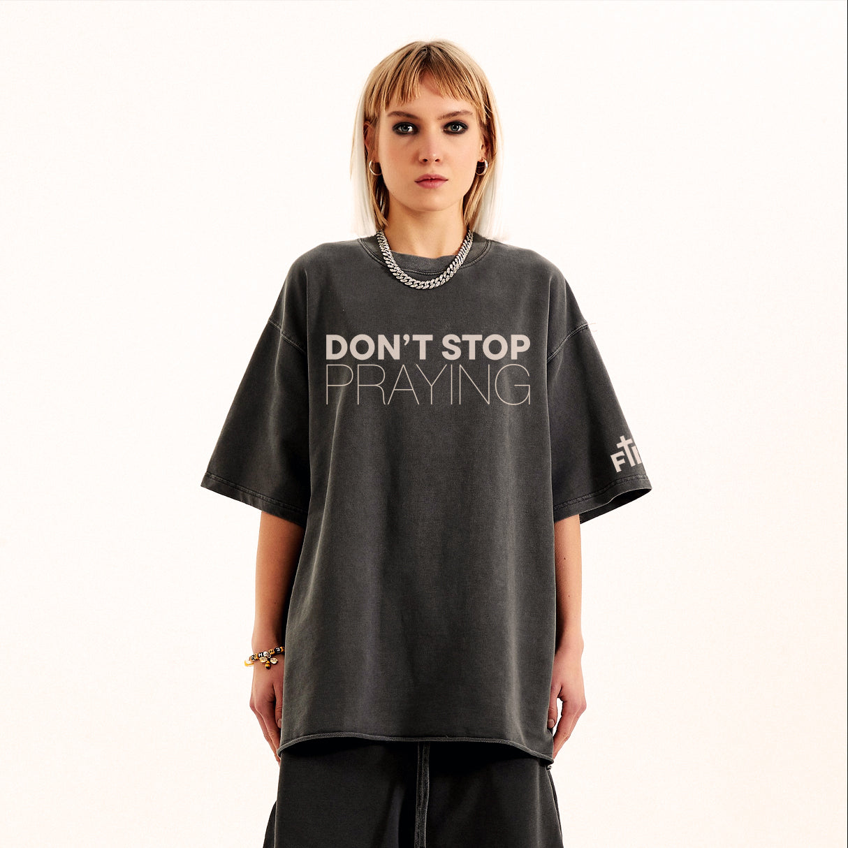 Person wearing a dark gray t-shirt with 'DON'T STOP PRAYING' text on a white background