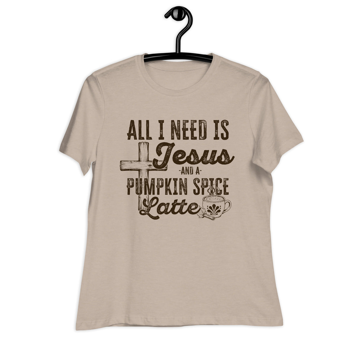 A beige short-sleeve t-shirt hanging on a black hanger against a white background, featuring a dark brown graphic print that reads 'ALL I NEED IS Jesus AND A PUMPKIN SPICE Latte' with a cross, coffee cup, and spice motif.
