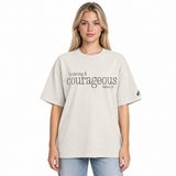 Front view of a faded bone oversized tee featuring black Be Strong & Courageous lettering, Joshua 1:9, and a small Faith Mode logo on the left sleeve.