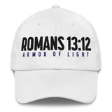 A white baseball cap featuring the text 'ROMANS 13:12' in bold black letters and 'ARMOR OF LIGHT' in dark blue below it, shown against a plain white background.
