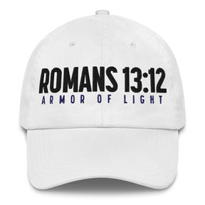 A white baseball cap featuring the text 'ROMANS 13:12' in bold black letters and 'ARMOR OF LIGHT' in dark blue below it, shown against a plain white background.