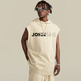 Person wearing a beige sleeveless hoodie with 'JOHN 14:6' text on a plain background