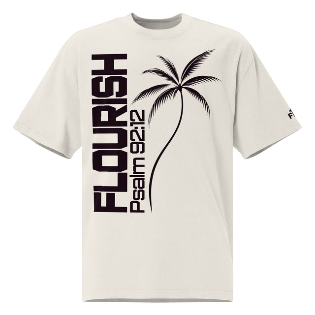 Front view of a faded bone oversized tee with dark plum vertical FLOURISH and Psalm 92:12 lettering, a palm tree graphic across the front, and a small logo on the sleeve.