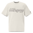 Front view of a faded bone oversized tee featuring black Be Strong & Courageous lettering, Joshua 1:9, and a small Faith Mode logo on the left sleeve.