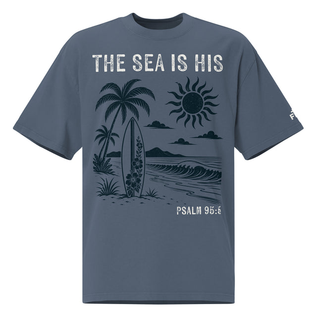 Front view of a Faded Indigo oversized tee featuring The Sea Is His, Psalm 95:5, palm trees, a surfboard, sun, ocean waves, and a small sleeve logo.