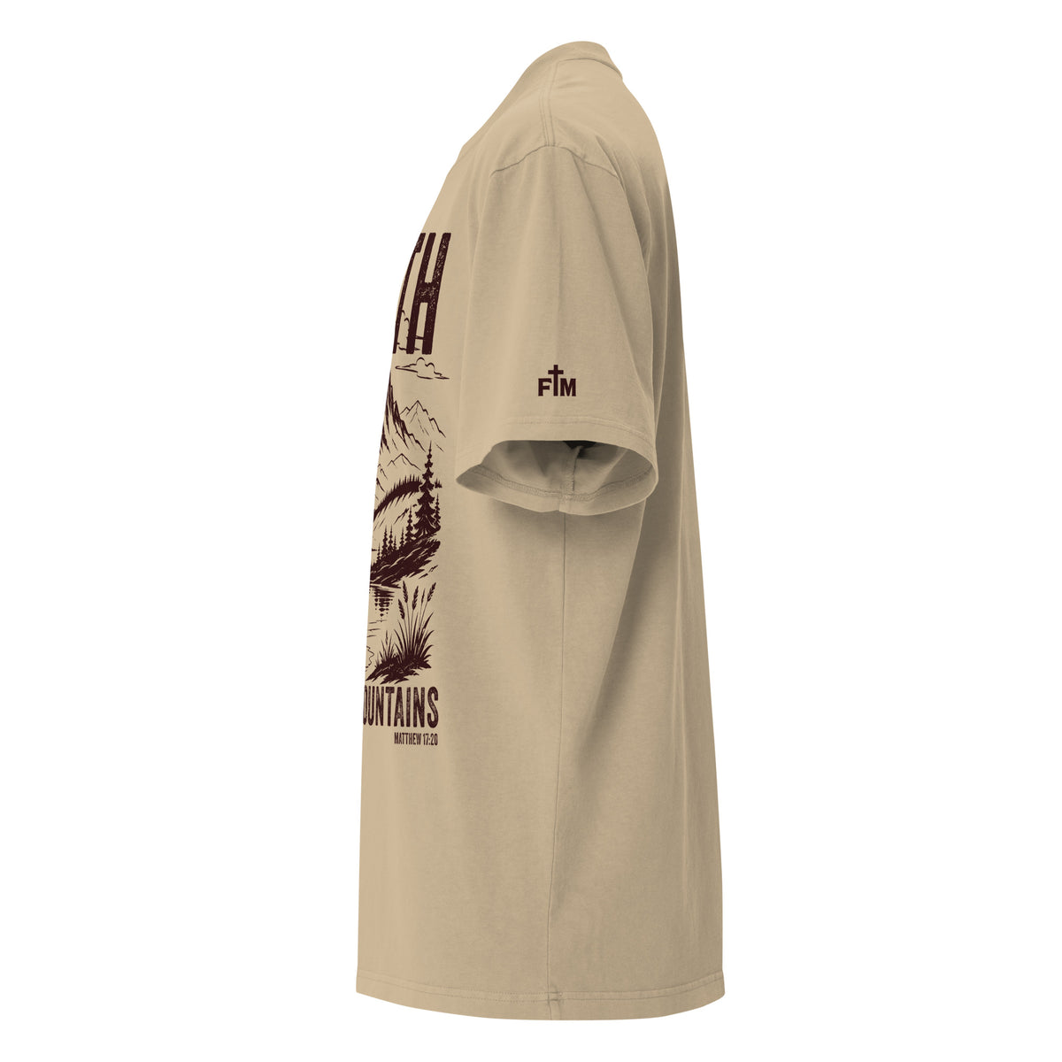 Side view of a Faded Khaki oversized tee featuring deep plum Faith Can Move Mountains lettering, a mountain and lake illustration, Matthew 17:20, and a small sleeve logo.