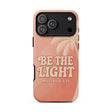 A peach-colored phone case featuring a tropical palm tree design and the text 'BE THE LIGHT MATTHEW 5:14' in a retro cream font, shown on a plain white background.