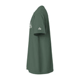 A dark green short-sleeve t-shirt shown from a side profile view against a plain white background. The shirt features white script lettering on the upper chest and a small white 'FM' (Faith Mode) logo on the left sleeve.