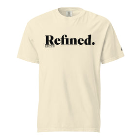 A cream-colored short-sleeve t-shirt with 'Refined.' printed in black serif font across the chest, accompanied by smaller text 'JOB 28:10' underneath, shown on a plain white background.