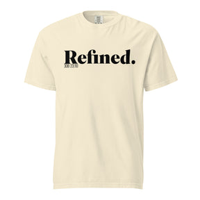 A cream-colored short-sleeve t-shirt with 'Refined.' printed in black serif font across the chest, accompanied by smaller text 'JOB 28:10' underneath, shown on a plain white background.