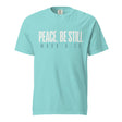 A light turquoise crewneck t-shirt with the text 'PEACE, BE STILL' and 'MARK 4:39' printed on the chest in a pale cream and dark gray font, shown against a plain white background.