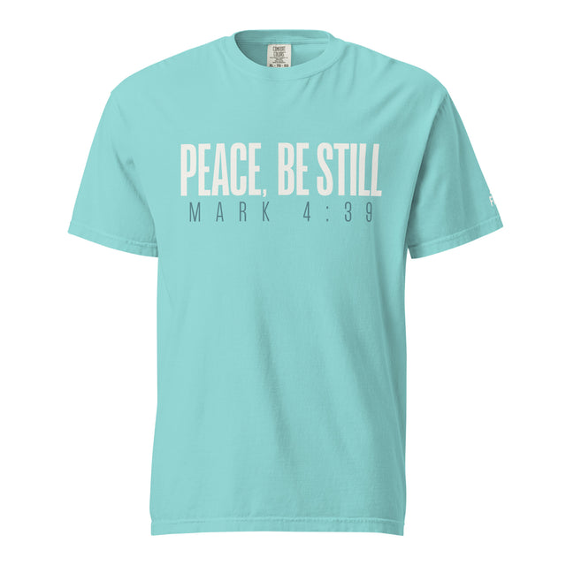 A light turquoise crewneck t-shirt with the text 'PEACE, BE STILL' and 'MARK 4:39' printed on the chest in a pale cream and dark gray font, shown against a plain white background.