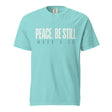 A light turquoise crewneck t-shirt with the text 'PEACE, BE STILL' and 'MARK 4:39' printed on the chest in a pale cream and dark gray font, shown against a plain white background.