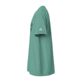 A sage green short-sleeve t-shirt shown from a side profile view against a solid white background. The shirt features a small white 'FM' logo on the right sleeve and a darker green graphic on the left chest.