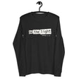 "Be The Light" "Matthew 5:14" in cream white designer grunge font on a black heather long sleeve shirt.