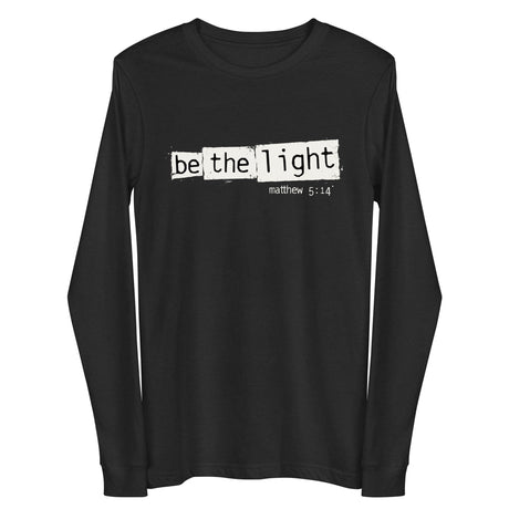 "Be The Light" "Matthew 5:14" in cream white designer grunge font on a black heather long sleeve shirt.