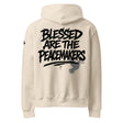 Beige hoodie with 'Blessed are the Peacemakers' text printed on the back of the hoodie in black ink.