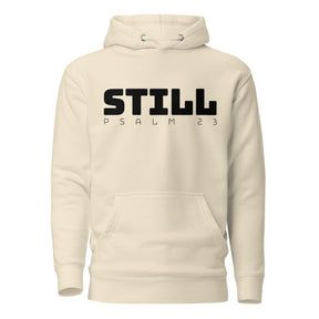 An off-white hooded sweatshirt with a black graphic print on the chest reading 'STILL PSALM 23', displayed against a solid white background.