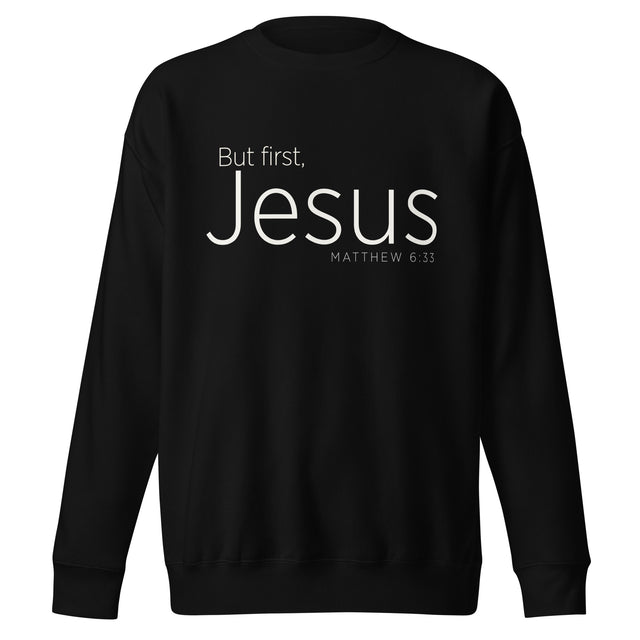 Black unisex sweatshirt with cream-white “But First, Jesus” typography and Matthew 6:33 printed on the front.