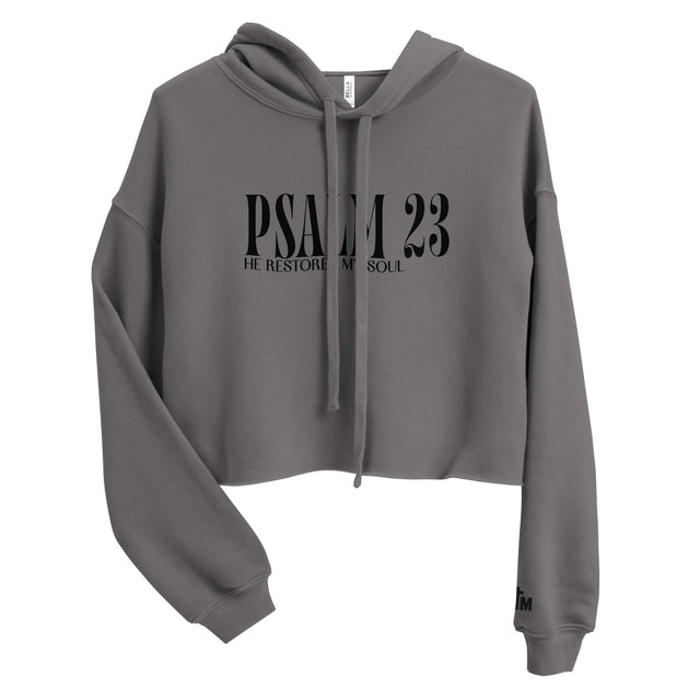 Front view of a Storm gray women’s crop hoodie with black “Psalm 23” lettering and “He Restores My Soul” beneath it, a drawstring hood, and long sleeves.