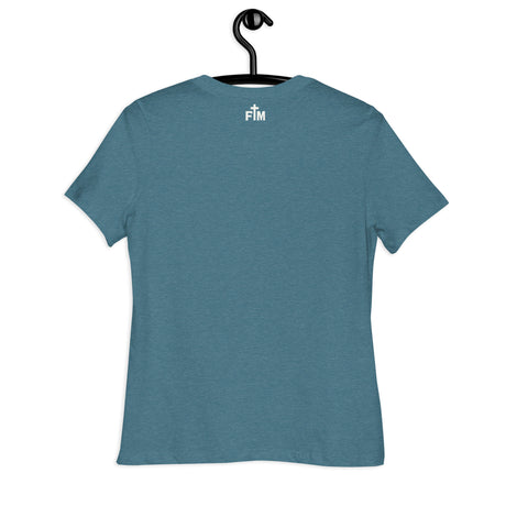 A heathered teal blue short-sleeve t-shirt hanging on a black hanger against a plain white background. The back of the shirt features a small white printed Faith Mode logo near the upper center containing the letters 'FM' and a small cross graphic between the letters.
