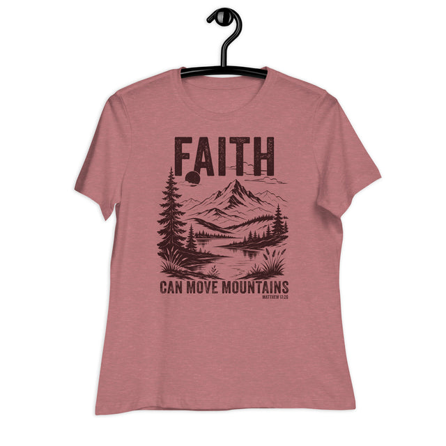 A heathered dusty rose short-sleeve t-shirt hanging on a black hanger against a plain white background. The shirt features a dark brown graphic print on the front with the word 'FAITH' above a mountain, lake, and pine tree landscape, with the text 'CAN MOVE MOUNTAINS' below.